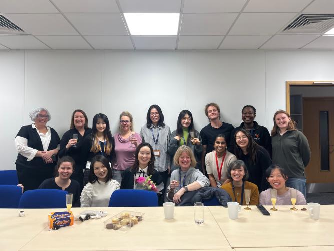 A picture of Kate Nation's lab members and friends celebrating Rainy's viva